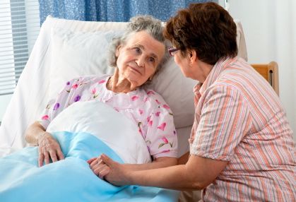 Senior woman with bedsores being comforted by daughter